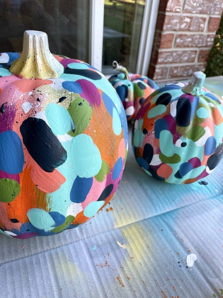 Close-up of DIY painted pumpkins with multi-color painted confetti details