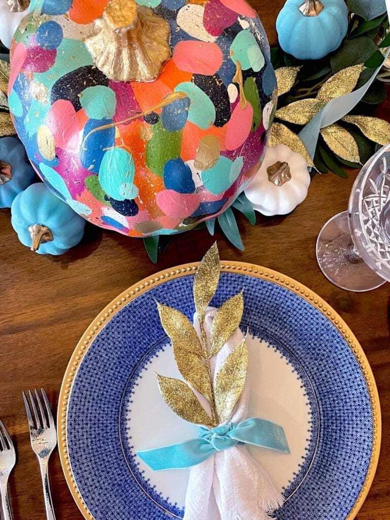 Detail of thanksgiving china with painted pumpkin centerpiece