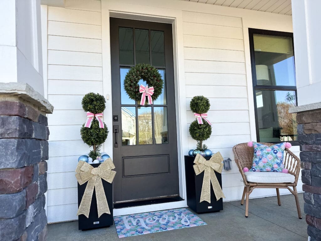 whimsical front holiday porch decorated for christmas in pinks and blues